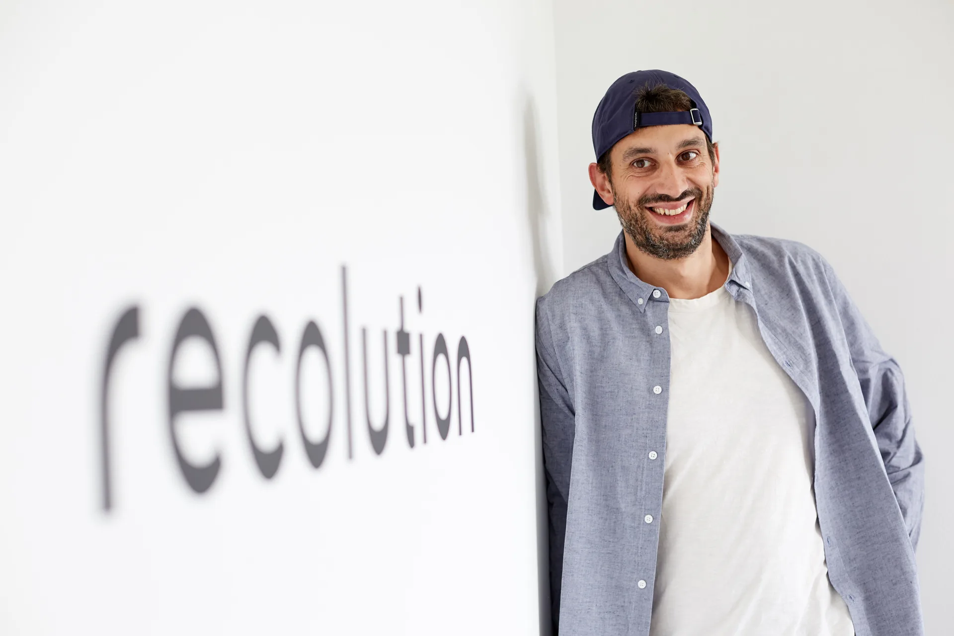 Marius, Head of Order Management bei Recolution, vor dem Recolution-Logo